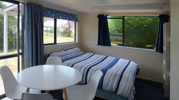 Studio interior showing double bed, table and chairs
